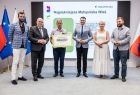 Uczestnicy wydarzenia stoją na scenie.