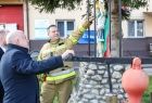 Wicemarszałek Ryszard Pagacz ogląda zabytkową strażacką pompę. 