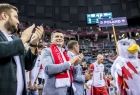 Marszałek Łukasz Smółka stoi na płycie areny. Obok przechodzi drużyna z napisem Poland.