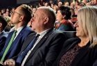 Wicemarszałek Ryszard Pagacz siedzi na widowni w kinie z innymi ludźmi.