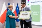 Uczestnicy wydarzenia stoją na scenie.