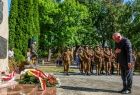 Wicemarszałek Ryszard Pagacz pochyla głowę przed pomnikiem. Przed nim leżą wieńce.
