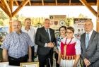 Wicemarszałek Ryszard Pagacz stoi z pod dachem z ludźmi.