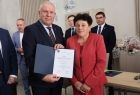 Wicemarszałek Ryszard Gawron stoi z kobietą w czerwieni.