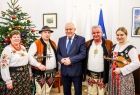 Wicemarszałek Ryszard Pagacz stoi w gabinecie z góralami. W tle widoczna choinka.