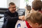 Wicemarszałek Witold Kozłowski wręcza prezent dziecku. 