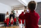 Zdjęcie grupowe z sześcioraczkami robione przez chłopca telefonem.