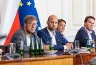 Czterech mężczyzn siedzi przy stole.