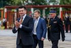 Wicemarszałek Łukasz Smółka klaska. Za nim widoczny radny województwa Mirosław Dróźdż i strażak.