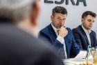 Marszałek Łukasz Smółka siedzi przy stole.
