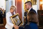 Iwona Gibas wręcza nagrodę samorządu województwa małopolskiego Złoty Medal Polonia Minor