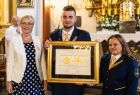 Przedstawiciele Amatorskiej Orkiestry Dętej Głębowice oraz Iwona Gibas z zarządu województwa prezentują wspólnie prestiżową nagrodę samorządu województwa małopolskiego