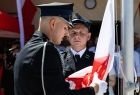 Strażacy wciągający biało-czerwoną flagę na maszt