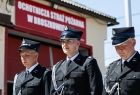 Strażacy w galowych mundurach na tle budynku OSP Broszkowice