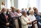 Seniorzy siedzą podczas uroczystości.