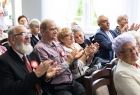 Seniorzy siedzą podczas uroczystości.