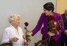 Marta Malec-Lech z zarządu województwa daje róże seniorom.