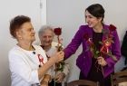 Marta Malec-Lech z zarządu województwa daje róże seniorom.