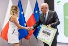 Uczestnicy wydarzenia stoją na scenie.