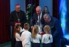 Wicemarszałek Ryszard Pagacz wręcza dzieciom prezenty.