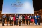Odznaczeni pracownicy stoją na scenie z wojewodą i Wicemarszałkiem Ryszardem Pagaczem.