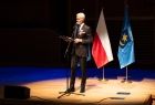 Mężczyzna w garniturze na scenie. 