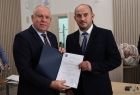 Wicemarszałek Ryszard Gawron stoi z sołtysem w marynarce pod krawatem.