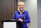 Iwona Gibas z zarządu województwa stoi przed mikrofonem przy mównicy.