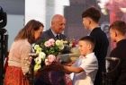 Dzieci z bukietem kwiatów składające życzenia Januszowi Marszałkowi oraz jego małżonce 