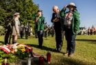 Wicemarszałek Ryszard Pagacz stoi przed pomnikiem w towarzystwie harcerzy.