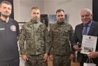 Wicemarszałek Ryszard Pagacz stoi na stali z żołnierzami.