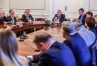 Uczestnicy spotkania siedzą przy stole.