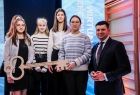 Wicemarszałek Łukasz Smółka stoi obok dzieci trzymających klucz.