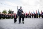 Wicemarszałek Łukasz Smółka idzie po placu z dziećmi w strojach strażackich.