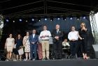 Uczestnicy wydarzenia stoją na scenie.