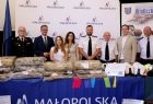 Uczestnicy wydarzenia stoją przed stołem napisem Małopolska.