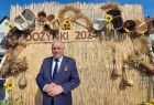 Wicemarszałek Ryszard Pagacz stoi na tle ścianki ze słomy z napisem Dożynki Zakliczyn.