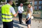 Wicemarszałek Ryszard Pagacz rozdaje dzieciom odblaski.
