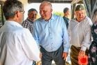 Wicemarszałek Ryszard Pagacz wita się z mężczyzną. Obok stoi mężczyzna w furażerce na głowie.