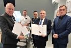 Wicemarszałek Ryszard Pagacz przekazuje dokumenty władzom gminy i strażakom.