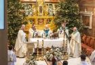 zbliżenie na ołtarz i księży celebrujących Mszę Świętą przed ołtarzem