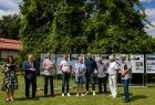 Uczestnicy wydarzenia w czasie symbolicznego otwarcia wystawy. Z tyłu widoczne plansze i zieleń.