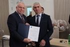 Wicemarszałek Ryszard Gawron stoi z mężczyzną i dokumentem.