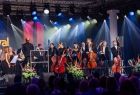 Muzycy orkiestry symfonicznej stojący na festiwalowej scenie 