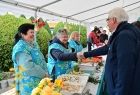 Wicemarszałek Józef Gawron podaje rękę kobiecie w niebieskim kwiecistym fartuchu.