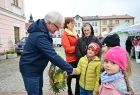 Wicemarszałek Józef Gawron podaje rękę dziecku w żółtej kurtce.