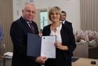 Wicemarszałek Ryszard Gawron stoi z kobietą i dokumentem.