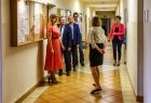 Wicemarszałek Witold Kozłowski na szkolnym korytarzu z grupą osób.