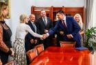Marszałek Łukasz Smółka podaje rękę kobiecie.