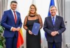 Kobieta w czarnej sukience z członkami zarządu.
